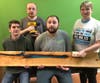 Vocational students at DoodleBug Workshop display a soon-to-be-table that incorporates blue resin into the wood slab.  They learn the many steps in the production process.