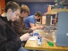 Students working in small teams engaged in a hands-on robotic build.