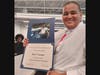 Mark Thompson holds his ACE Academy certificate and a photograph from an aircraft flight-deck experience.