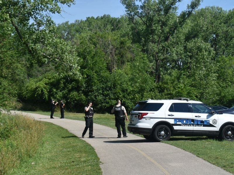 A Northfield Police Department vehicle and Cook County sheriff's police close a bike trail after three carjackers reportedly took off running into Cook County Forest Preserve District property Thursday morning.