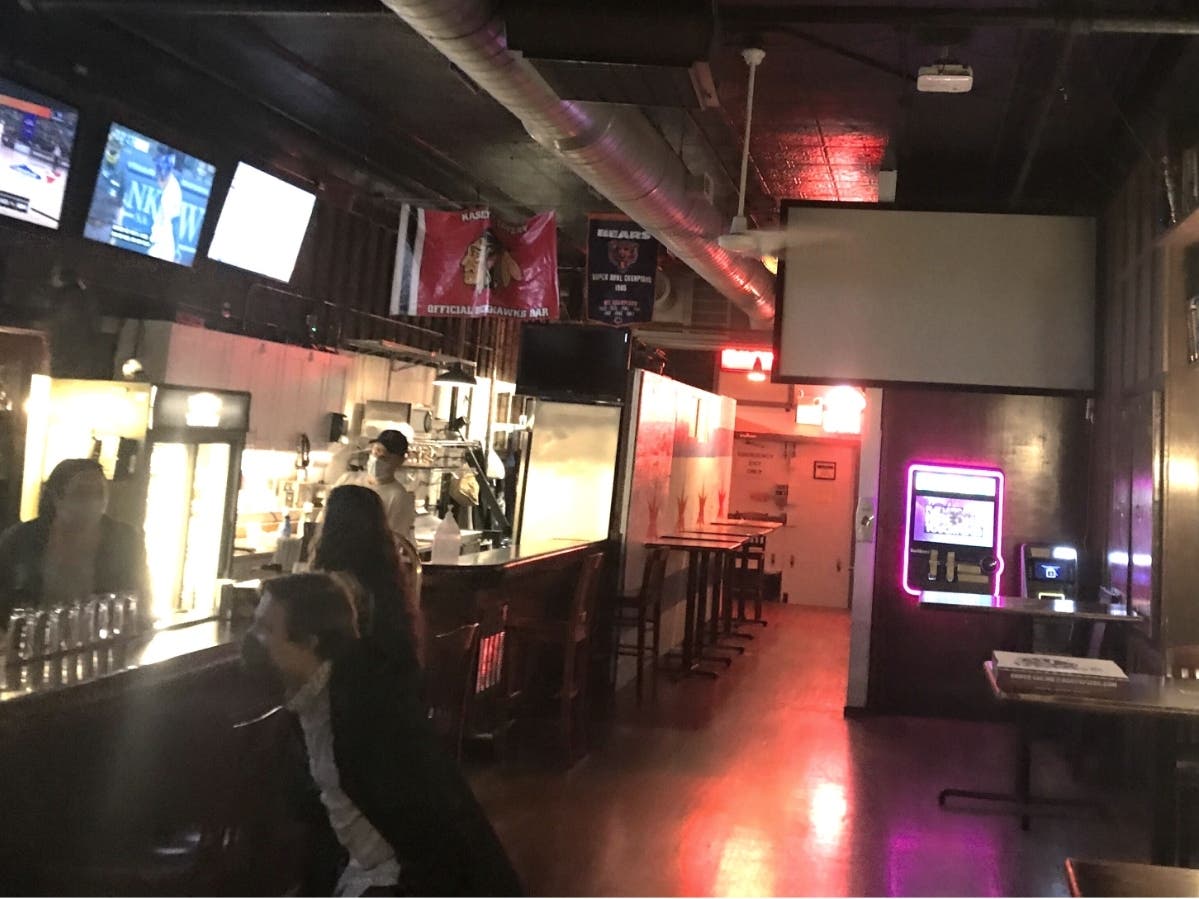 Patrons and staff at a Chicago tavern are shown wearing face coverings while interacting, as required under statewide guidelines set to go into effect Wednesday.