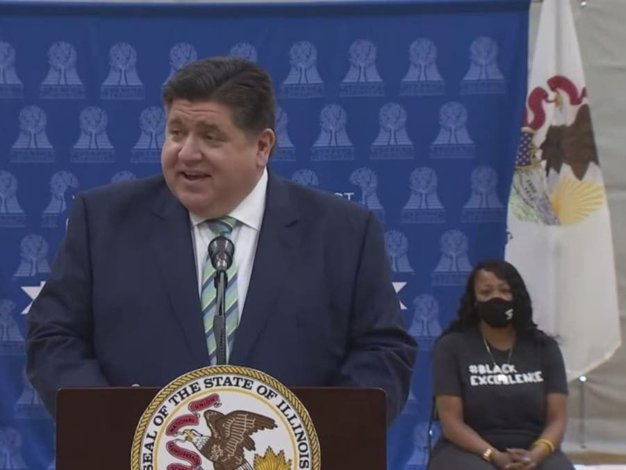 Gov. J.B. Pritzker speaks as LaToya Howell waits to address at a news conference Wednesday at the Waukegan Park District Field House.