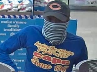 A man suspected in seven armed robberies since early April is pictured wearing a shirt saying, "having the courage to put on the cape" on an image captured from surveillance video Tuesday in Elmhurst.