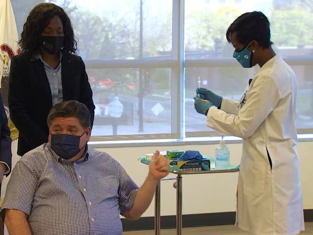 Gov. J.B. Pritzker prepares to receives a booster shot of the COVID-19 vaccine Tuesday in Chicago.