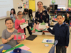 Troy Hofer Elementary School students in teacher Jennifer Komosa’s class show the “money” they’ve earned with classroom jobs so far this year. From left, Autumn, Olivia, Komosa and Daniel.