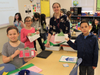 Troy Hofer Elementary School students in teacher Jennifer Komosa’s class show the “money” they’ve earned with classroom jobs so far this year. From left, Autumn, Olivia and Daniel.