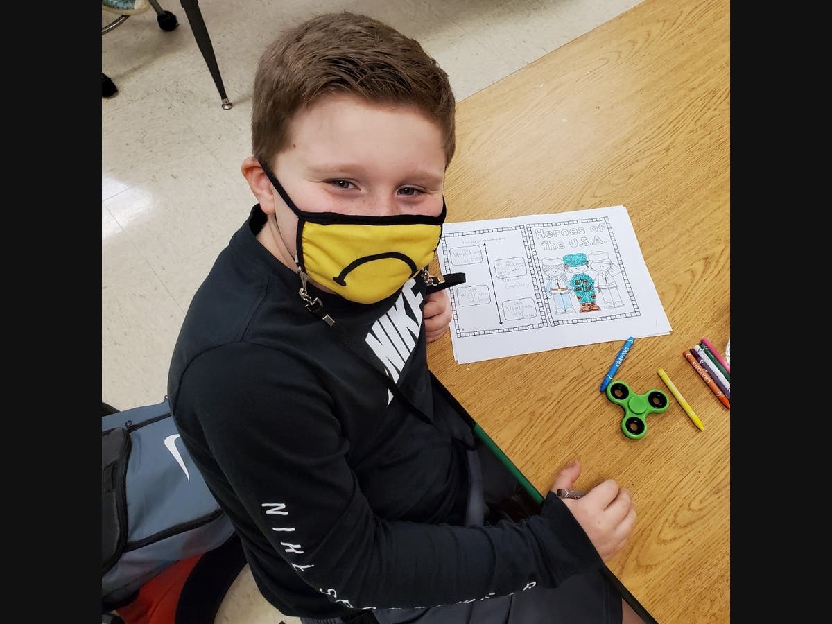 Troy Craughwell Elementary School student Callen Foster colors a picture for a letter he wrote to a veteran.