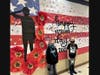 Second grade twins at Troy Heritage Trail Elementary School with the flag wall mural made by students and art teacher Lauren Sandeno.