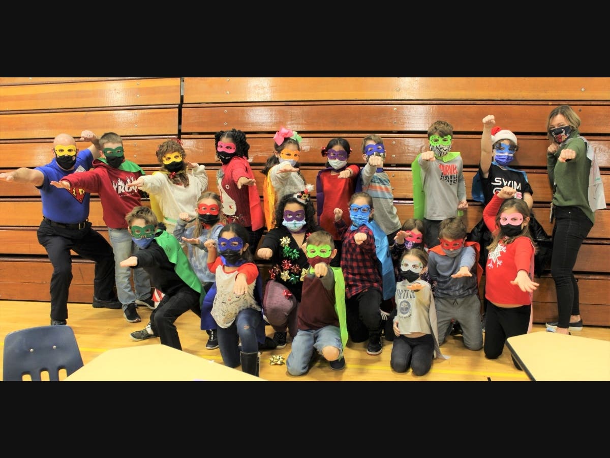 Troy Shorewood Elementary School teacher Bridget McMahon (upper right), Channahon Fire Protection Chief John Petrakis (upper left), with McMcMahon’s students, demonstrating their superhero stances.
