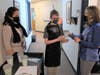 A W.B.O. Special Education Life Skills student, along with teaching assistant Saima Malik,  delivers coffee to social worker Erika Keen in the class’s Coffee Cart program.