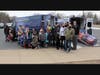 Second graders at Troy Craughwell Elementary School, along with Troy staff and volunteers, help bring in donations from Enchanted Backpack’s mobile van.