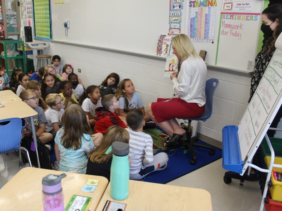 Troy Hofer Elementary School Principal Kristin Copes reads a book to teacher Alexa Johnson’s class