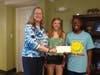 Katelyn O'Connor, center, presents check from summer dance party fundraiser to Anna's House with We Cancerve founder