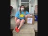 Ashlee Brockwell, a member of We Cancerve's all-youth board of advisors, sits with Bimbo Bakeries' donations of Entenmann's Little Bites.
