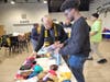 Members of the Iota Alpha Lambda Chapter of Alpha Phi Alpha Fraternity, Inc. add satin bonnets to Black hair care kits they helped pack.