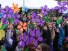 Walkers hold up purple flowers in honor of loved ones they have lost to Alzheimer's during the opening ceremony.