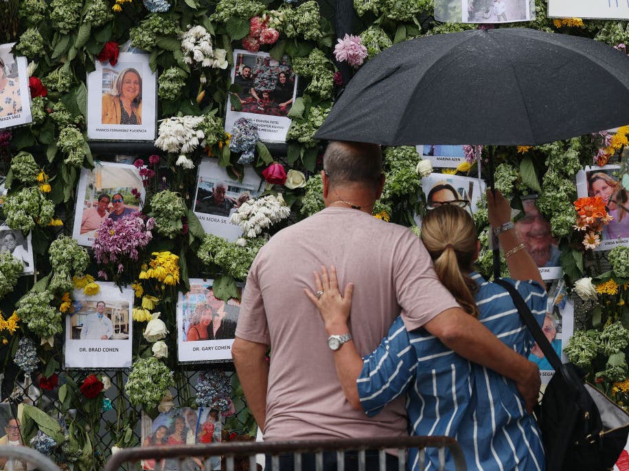A couple views the makeshift memorial for the victims of the condominium collapse in Surfside, FL. 
