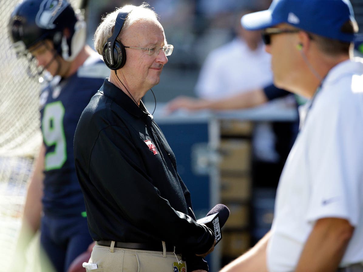 FILE - John "The Professor" Clayton, an NFL football writer and reporter for ESPN, stands on the sideline during an NFL football game between the Seattle Seahawks and the San Francisco 49ers, Sunday, Sept. 25, 2016, in Seattle. Clayton died Friday. 
