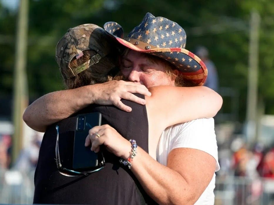 People hug after Republican presidential candidate former President Donald Trump was helped off the stage at a campaign event after an attempted assassination attempt. 