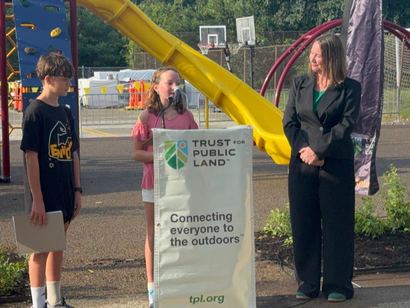 A Greenfield Pre-K-8 Neighborhood School student speaks at the opening ceremony for the school's new schoolyard.