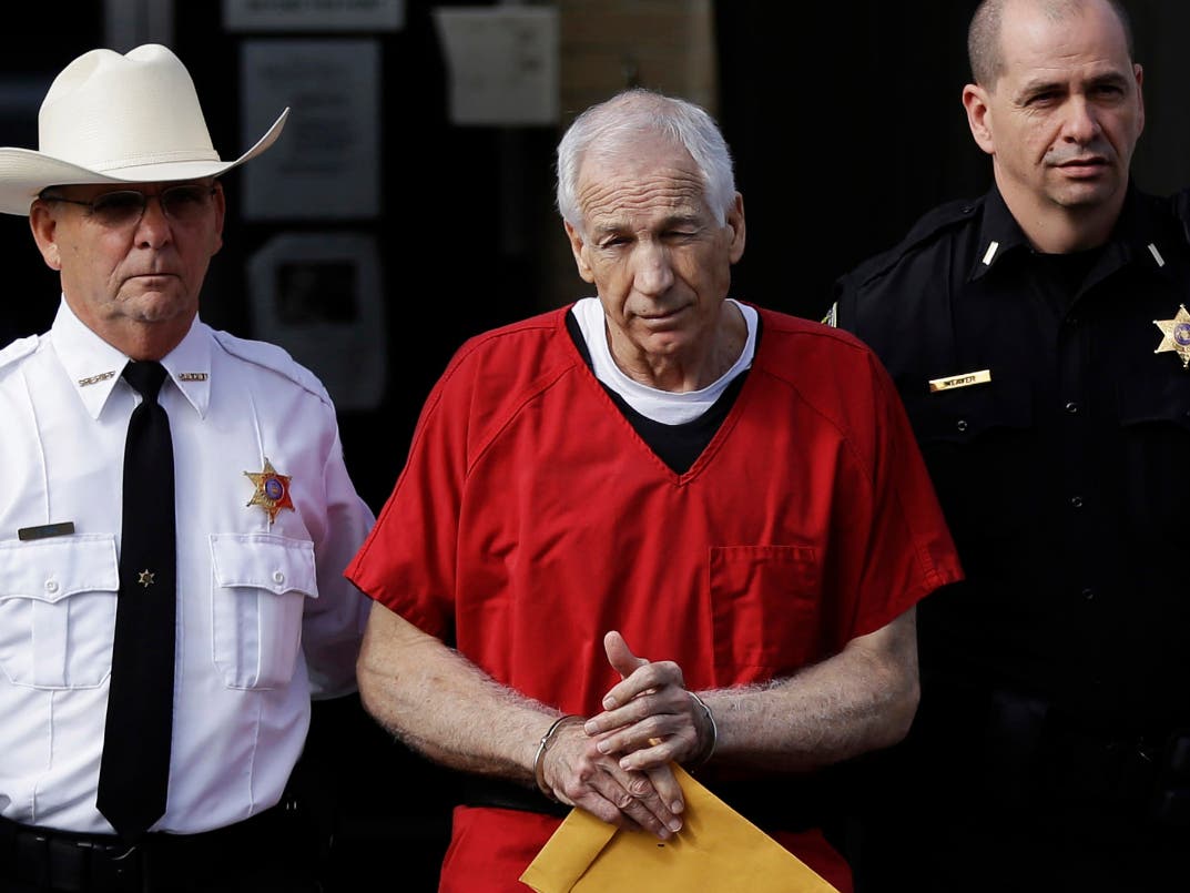 FILE - In this Oct. 9, 2012 file photo, former Penn State University assistant football coach Jerry Sandusky, center, is taken from the Centre County Courthouse after being sentenced in Bellefonte, PA.