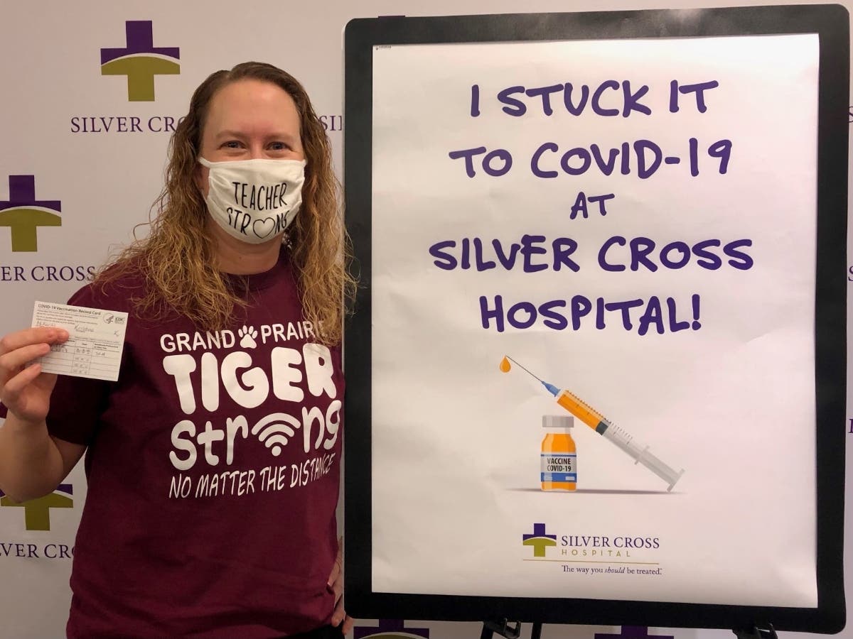 Kris McKuras, 1st grade teacher at Grand Prairie Elementary School, poses after receiving her first dose of the COVID-19 vaccine at Silver Cross.