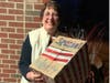 Jane Devlin from Wayside Well displays a special delivery box of anonymous pen pal letters and lotions from Daisy Girl Scout Troop 98191 ready for distribution to her homeless friends.