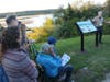 Richard Grant, President of Narrow River Preservation Association, welcomes guests to the unveiling of an informational panel celebrating the little red shack on Sedge Island in Narrow River.