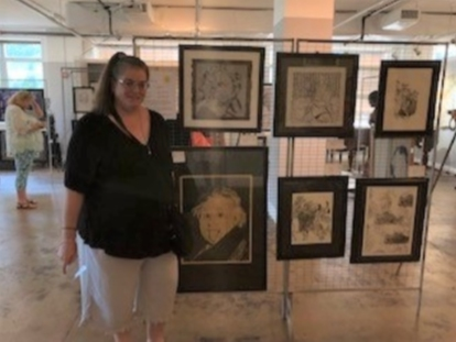 Artist Sue Zywokarte stands next to her prints, displayed at Pathway Homes’ Summer for the Arts exhibit at the Vienna Arts Society.
