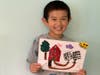 Second place winner Eli shows his art for the Ipsun Sunny Summer Art Contest.
