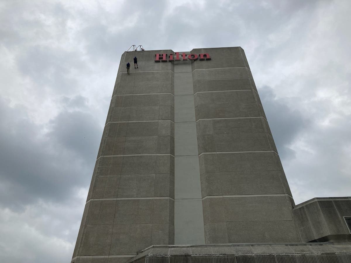 Fairfax County Board of Supervisors Chairman Jeff McKay and Arlington County Board member Matt de Ferranti rappel down the 14-story Hilton Crystal City to raise money and awareness for New Hope Housing, a homeless services organization.