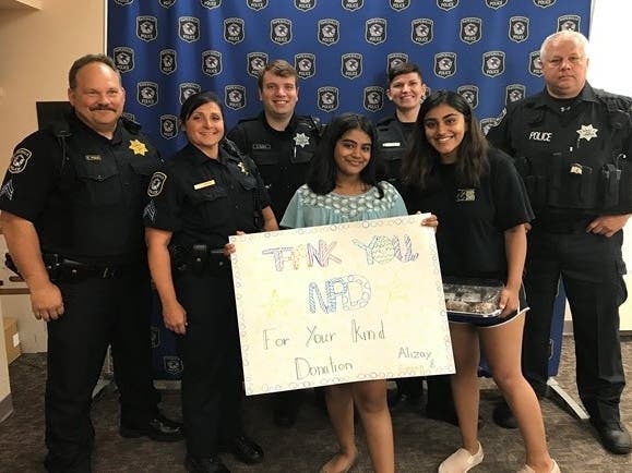 Emaan and Alizay Kashif thanked Naperville police for helping them raise more than $300 at their lemonade stand. 