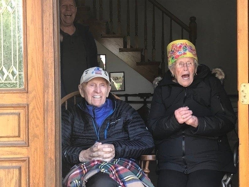 Jim and Margaret Riordan watch a car parade held in their honor for their 66th wedding anniversary.
