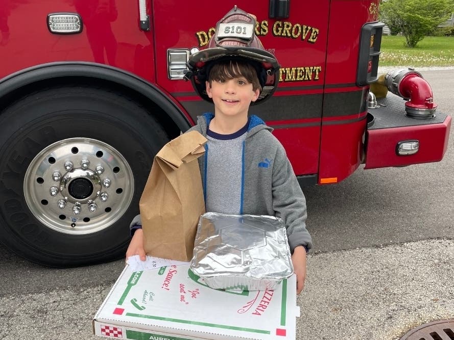 Jake Lazzeri, 9, poses in front of a Downers Grove Fire Department truck. Jake's fire escape video recently won a contest held by the fire department and District 58. 