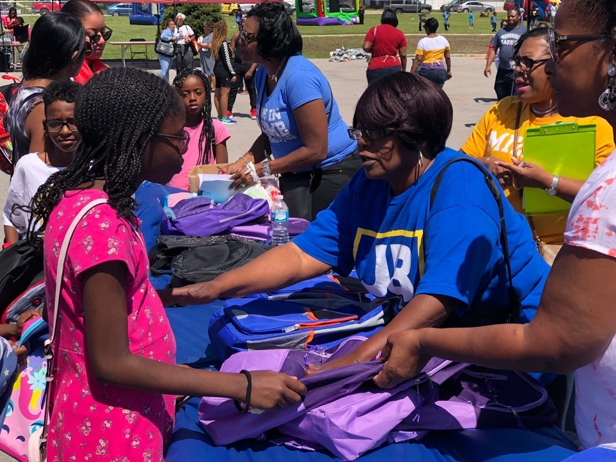 Dolton 149 Superintendent Dr. Shelly Davis-Jones (background) and Board President Darlene Gray Everett (foreground) distribute free backpacks at Back-to-School Carnival.