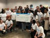 Raquel "Rocky" Egusquiza with the Miami Marlins Foundation, center, is presented with a a $25,000 check from AT&T's Thais Asper, left of Egusquiza, and Cristal Cole, right of Egusquiza