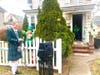 Councilman/Vocalist Gaitley Stevenson-Mathews prepares to sing “Danny Boy” from the sidewalk, as 96-year-old WWII veteran Robert O’Neill watches from his doorway. 
