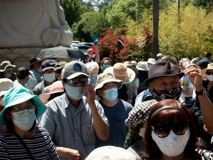 People line up for hot meals, fresh groceries and free masks at the Di Lac Temple in San Jose.