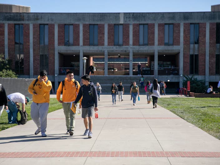 Students walk near Meiklejohn Hall at California State University East Bay. Photo by Anne Wernikoff for CalMatters