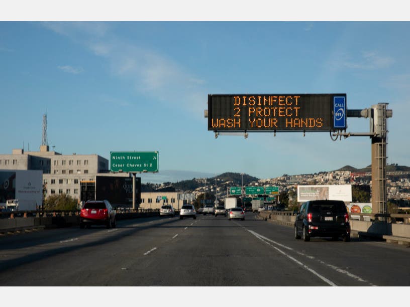 A sign reminding drivers to wash their hands hangs above I-280 in San Francisco on the first day of the three-week shelter in place mandate. 