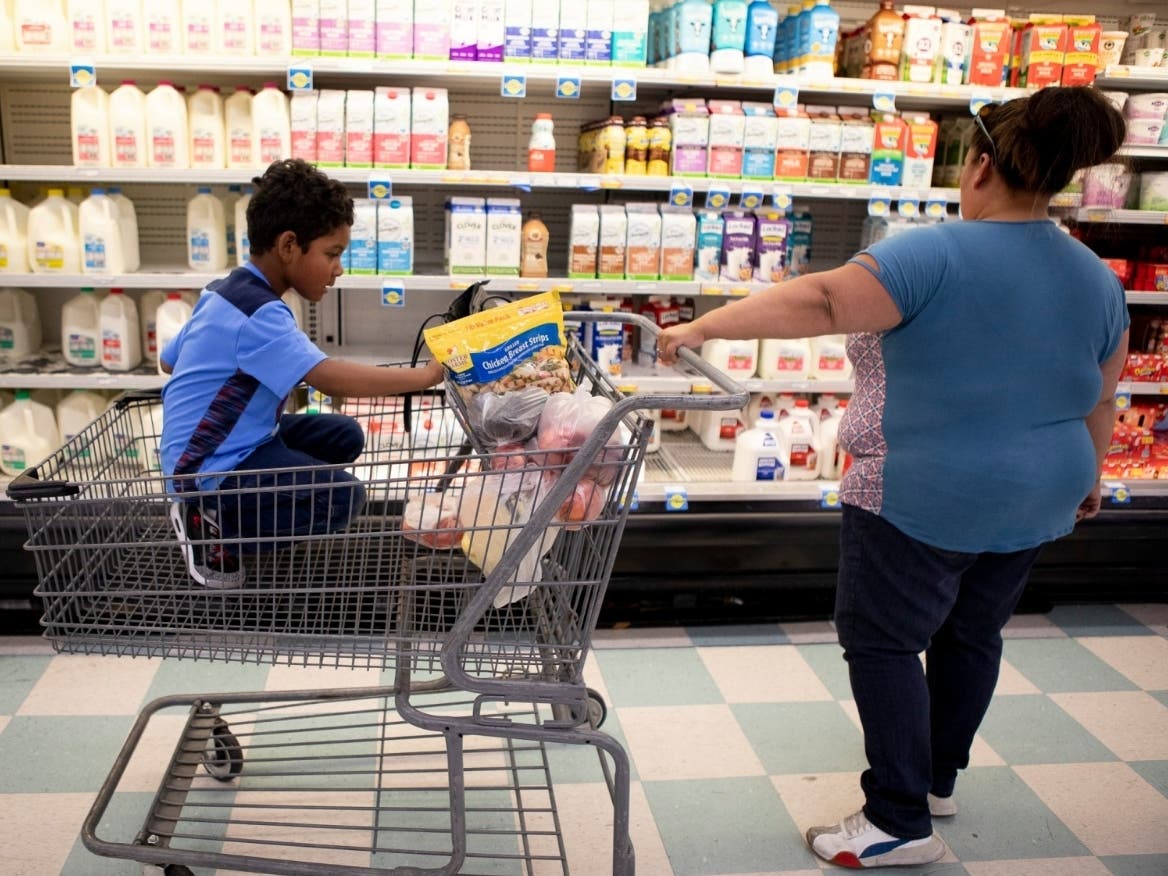 California is sending pandemic food cards to qualifying students. In this file photo, Antionette Martinez and her son Caden, 5, who receive CalFresh, do their weekly grocery shop at FoodMaxx on July 26, 2019.