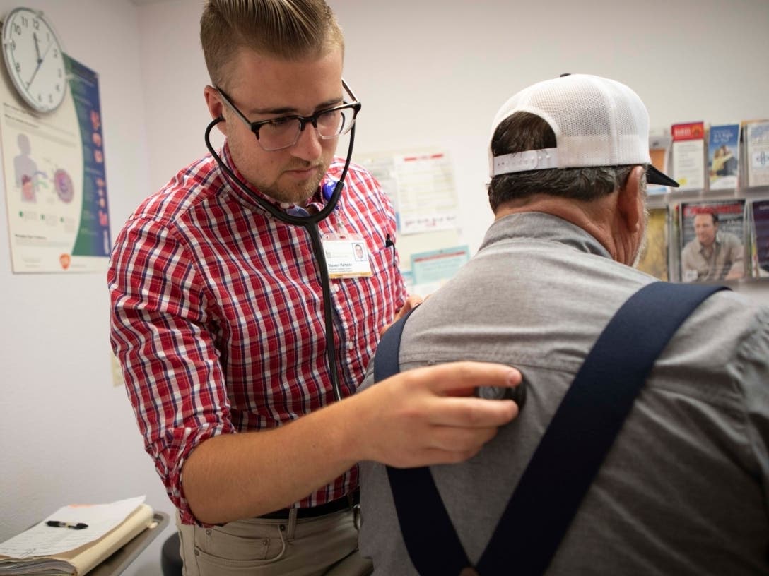 A physician's assistant listens to a patient's breathing at a clinic in Bieber, California on July 23, 2019.