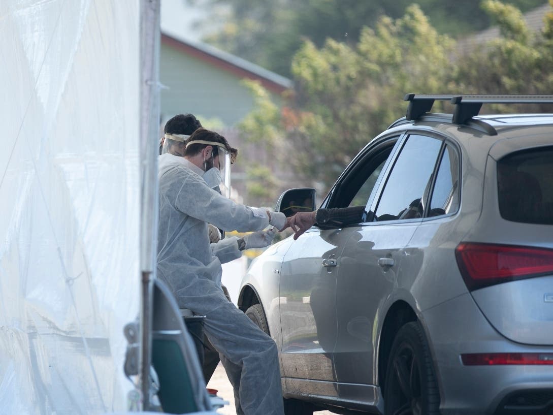 A phlebotomist takes a finger prick blood sample at a drive-through COVID-19 testing site in Bolinas on April 22, 2020. Bolinas is attempting to test the entire town in conjunction with a UCSF study, one of the first efforts of its kind in California.