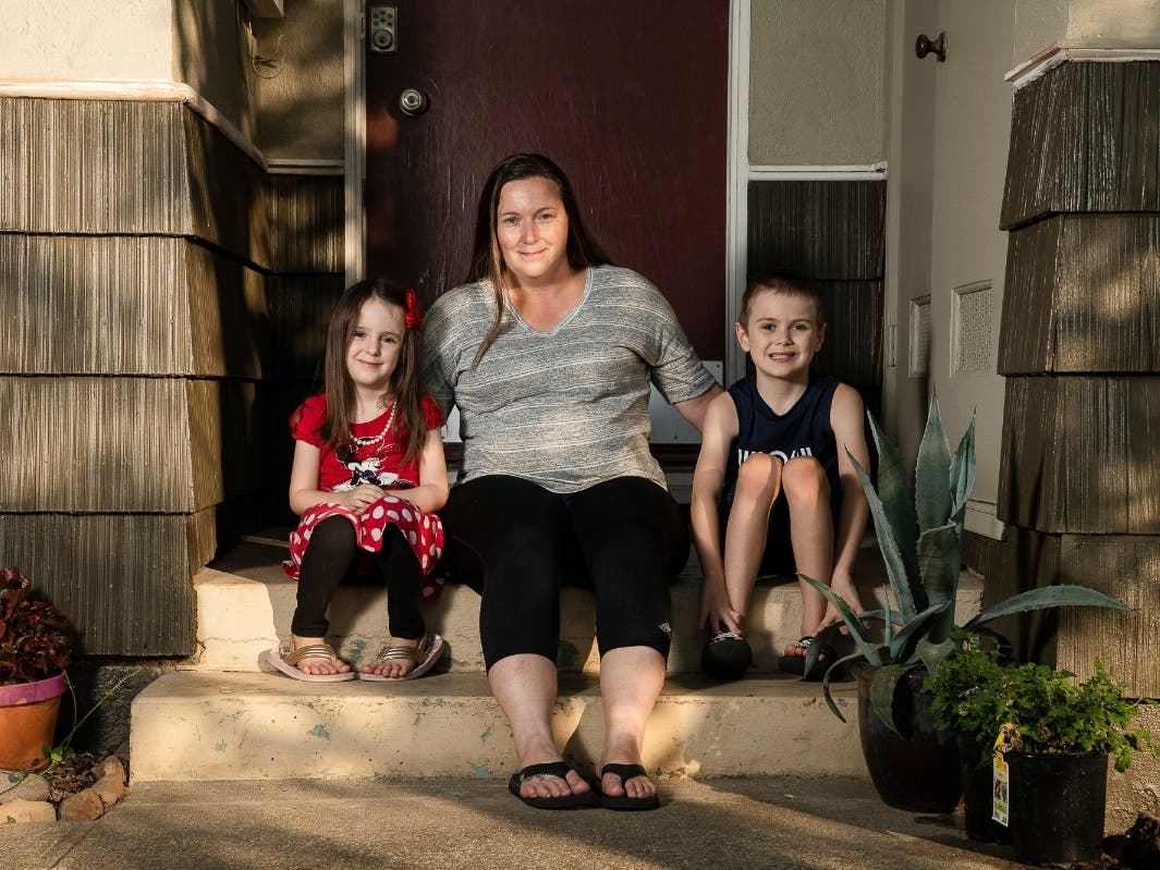 Kyla Hill, 5, left, Rebecca Hill, center, and Kaden Hill, 7, right, sit for a portrait at their home in Chico on July 23, 2020. Rebecca has to balance what's best for her children's education with their safety and that of her immuno-compromised husband.