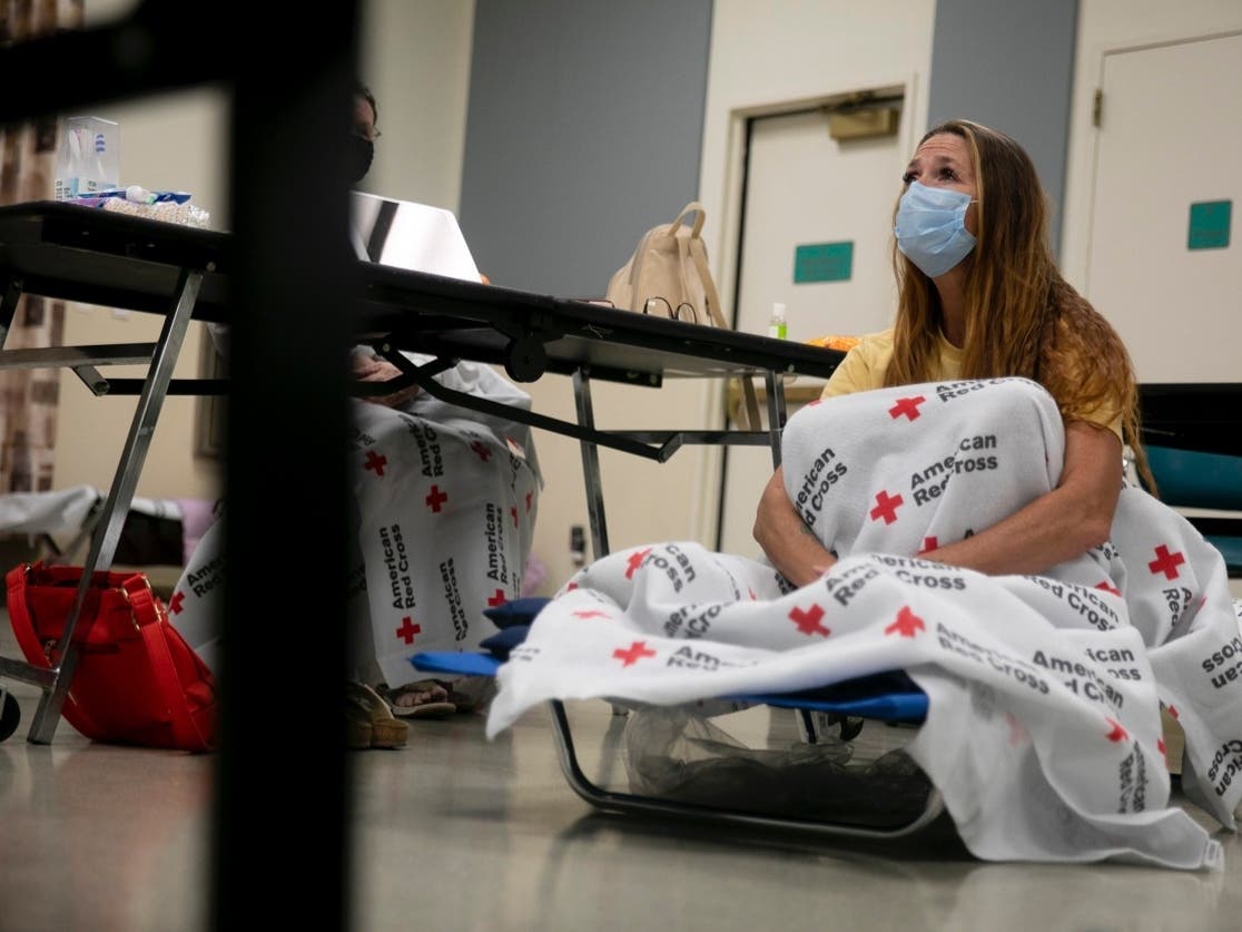 Shawnee Whaley, 57, wears a mask as she rests on a cot at the Ulatis Community Center in Vacaville after evacuating her home on August 18, 2020. 