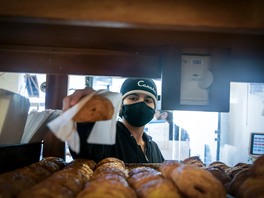 Luna Walker bags chocolate croissants for patrons at Nabolom Bakery in Berkeley on Jan. 19, 2022. 
