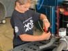 An EXCITE camper participating in "The Pit" works on an ATV.
