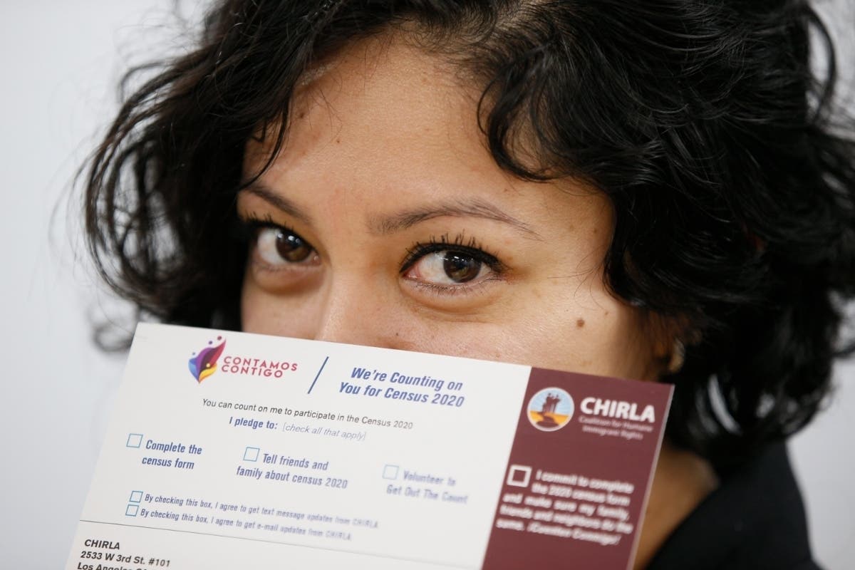 Coalition for Humane Immigrant Rights organizer Diana Escamilla shows census campaign cards at the CHIRL office.
