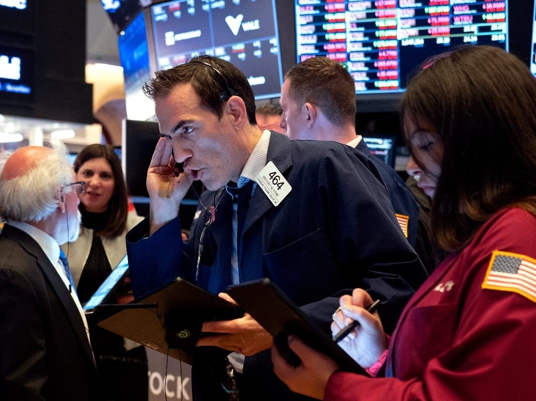 Trader Gregory Rowe, center, and others work on the floor of the New York Stock Exchange Monday, March 16, 2020.