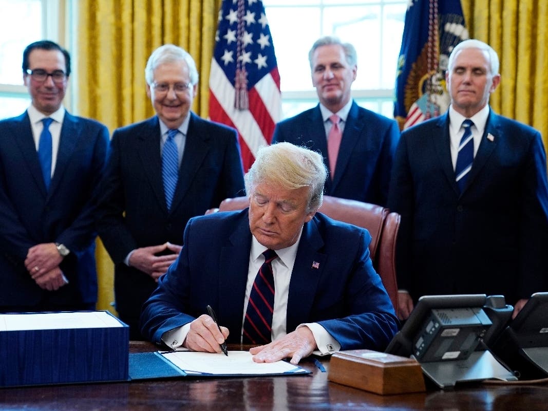 President Donald Trump signs the coronavirus stimulus relief package, at the White House, Friday, March 27, 2020, in Washington.